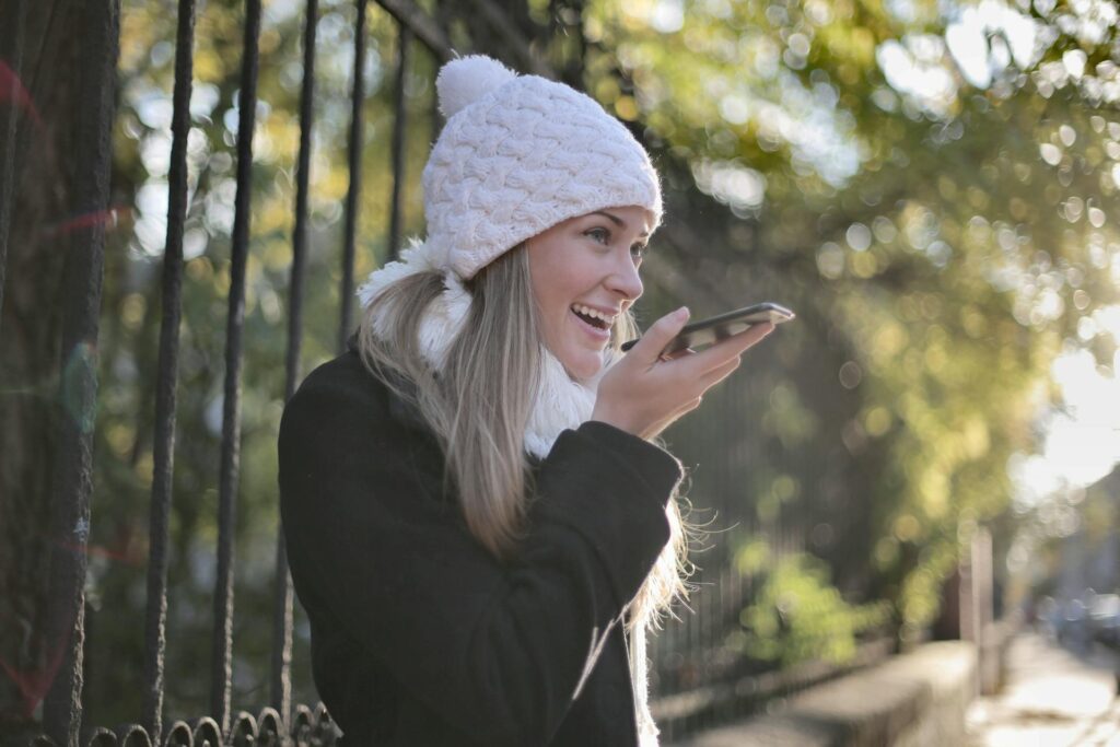 A smiling woman talking into her phone.